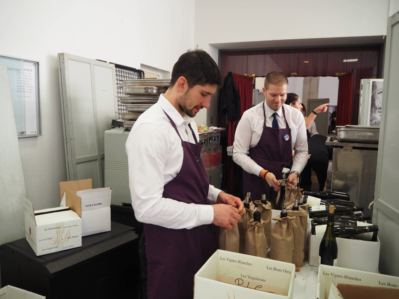 "Préparation des bouteilles de vin pour le service lors du banquet."