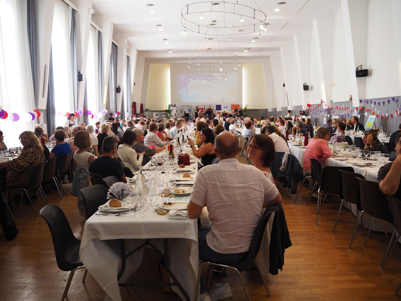 Vue d'ensemble des tables avec de nombreux convives lors de l'apéritif.